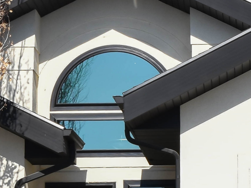 Custom arched window with black frame and picture window on stucco home in Utah