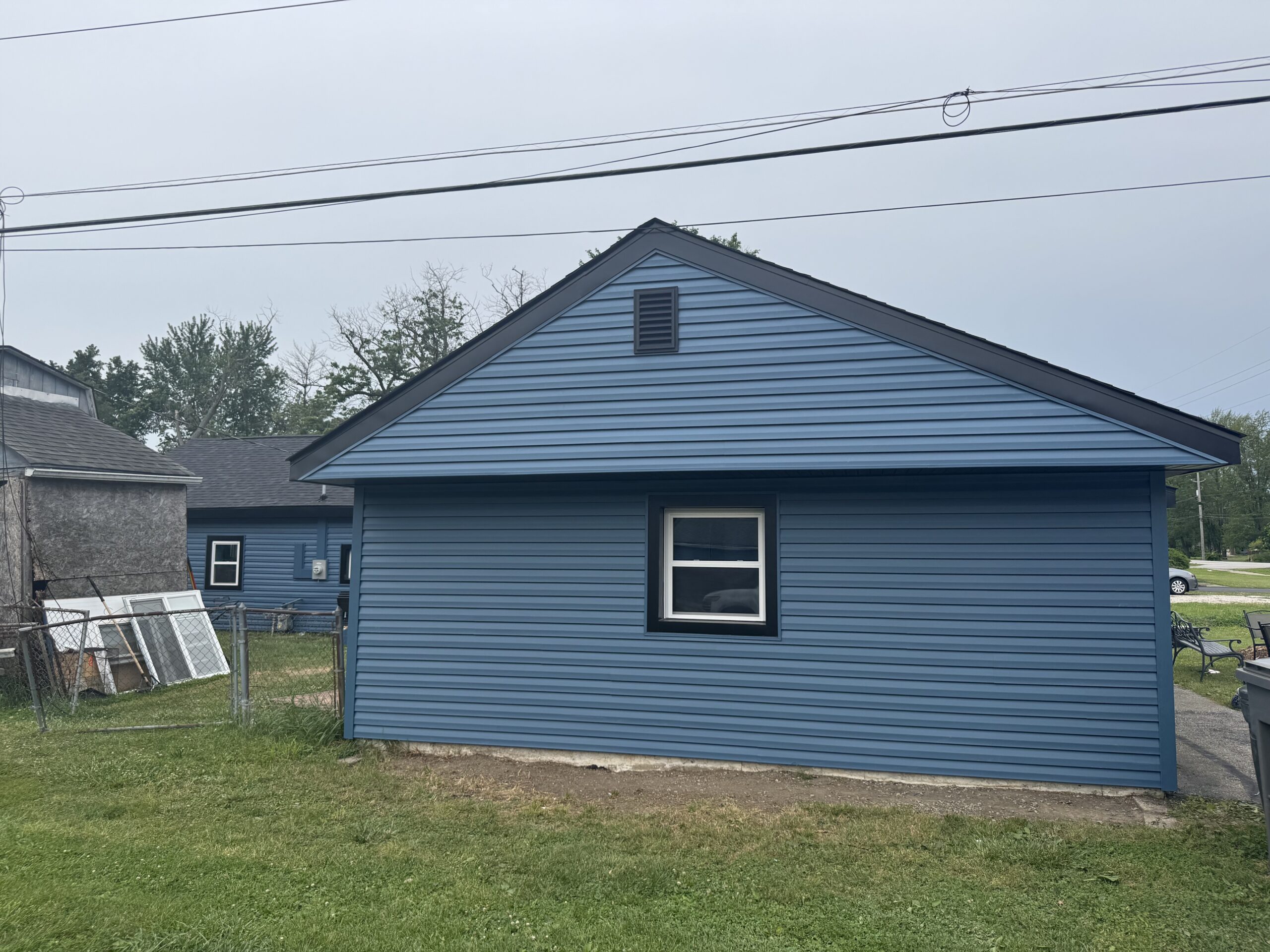 Gable end after Indianapolis siding replacement with Laguna Blue siding and black trim details